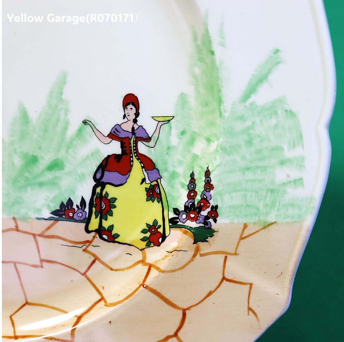 ヨーロッパで作られた陶器製プレートと金属脚を組み合わせたアンティークのケーキスタンド＿女性アップ