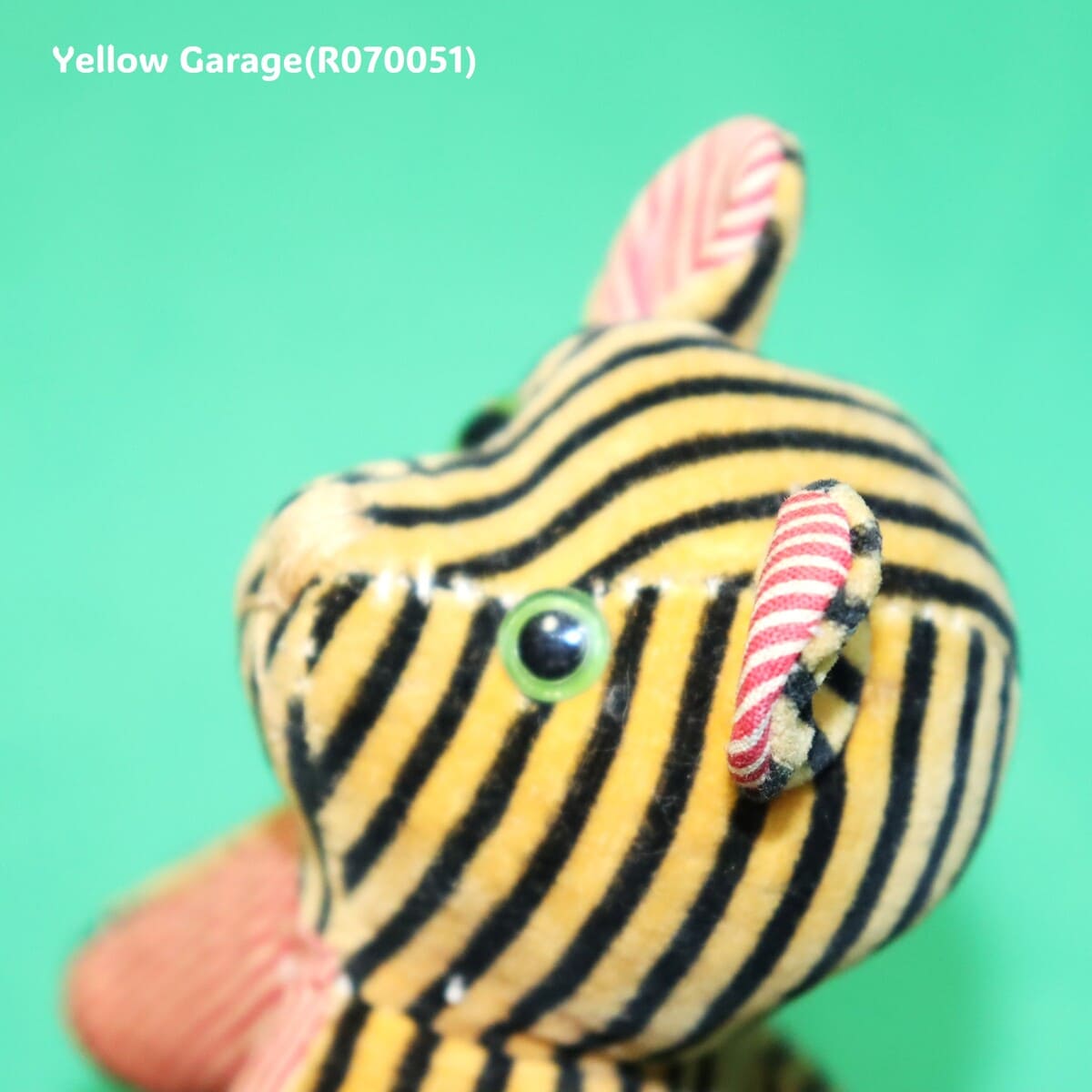 ビロード調の布（ベルベット生地）に縞模様プリント、耳と手足の裏に赤白ストライプ生地のぬいぐるみ横顔