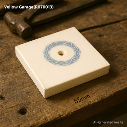 中央に青色のリース状の模様が描かれたアンティークの装飾タイル