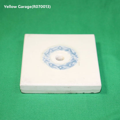 中央に青色のリース状の模様が描かれたアンティークの装飾タイル