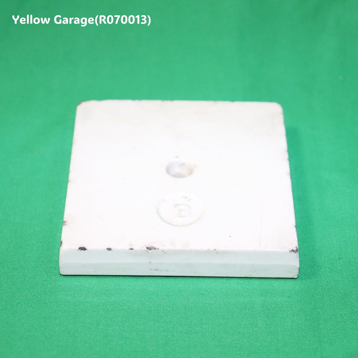 中央に青色のリース状の模様が描かれたアンティークの装飾タイル