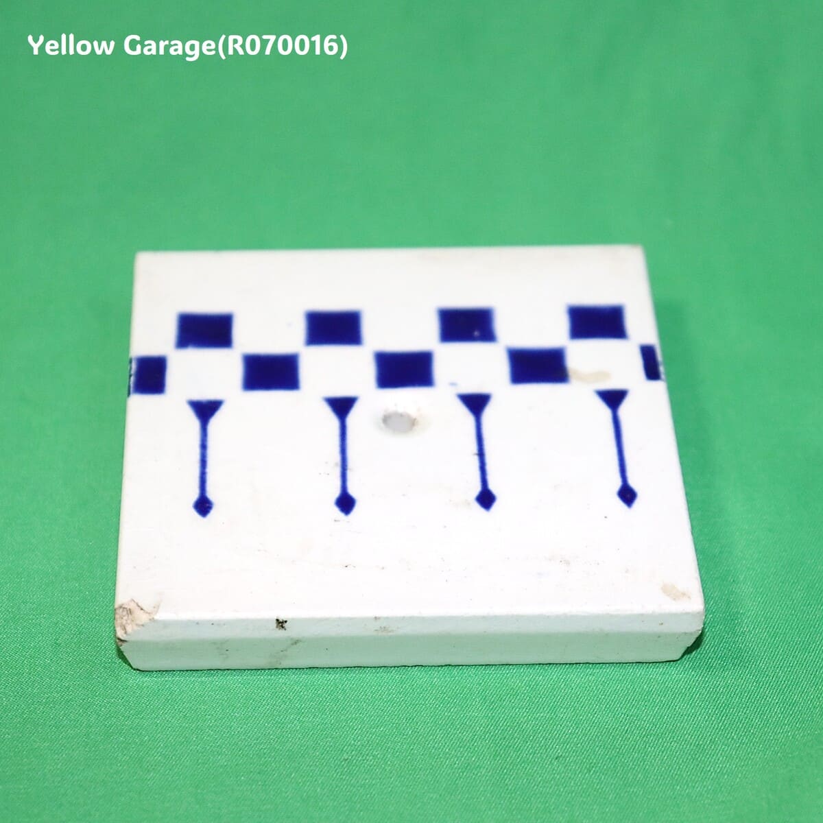 一辺が約85mmの小ぶりなサイズで、白地に深い藍色の幾何学模様（チェッカーボードと縦の矢のようなライン）が描かれています。