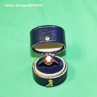 中心には遊色効果が美しいオーストラリア産ホワイトオパール、周囲には天然ルビーと思われる赤い石が繊細に取り巻かれた華やかなアンティークリング