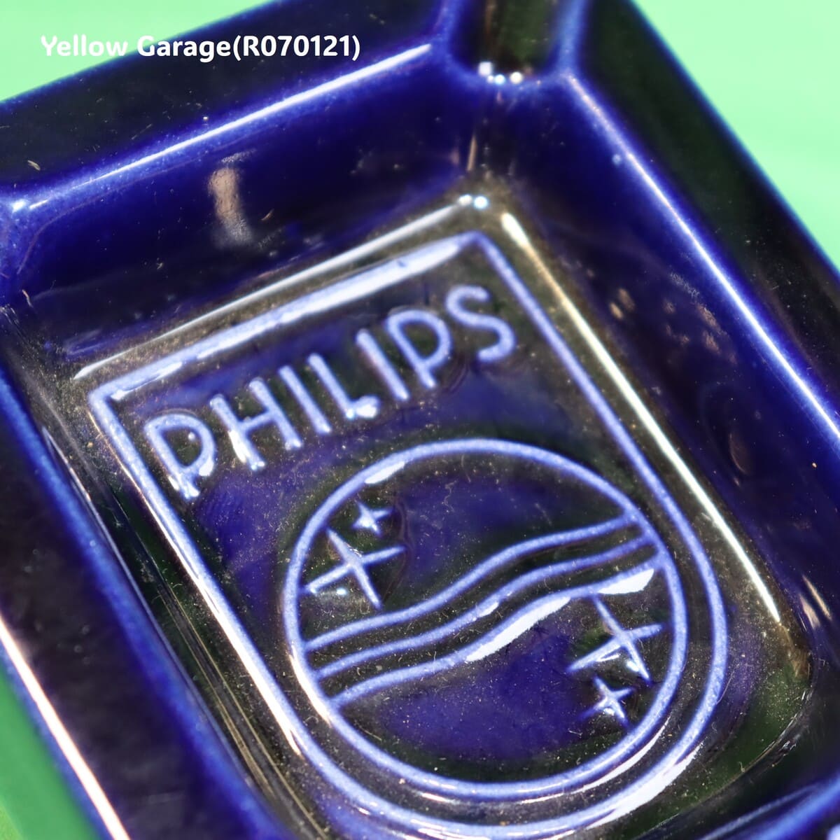 オランダの電機メーカーPHILIPS（フィリップス）のロゴとスローガン「C'EST PLUS SÛR（それはより安全）」が刻まれた深い青の美しい陶器製灰皿＿斜め兆アップ