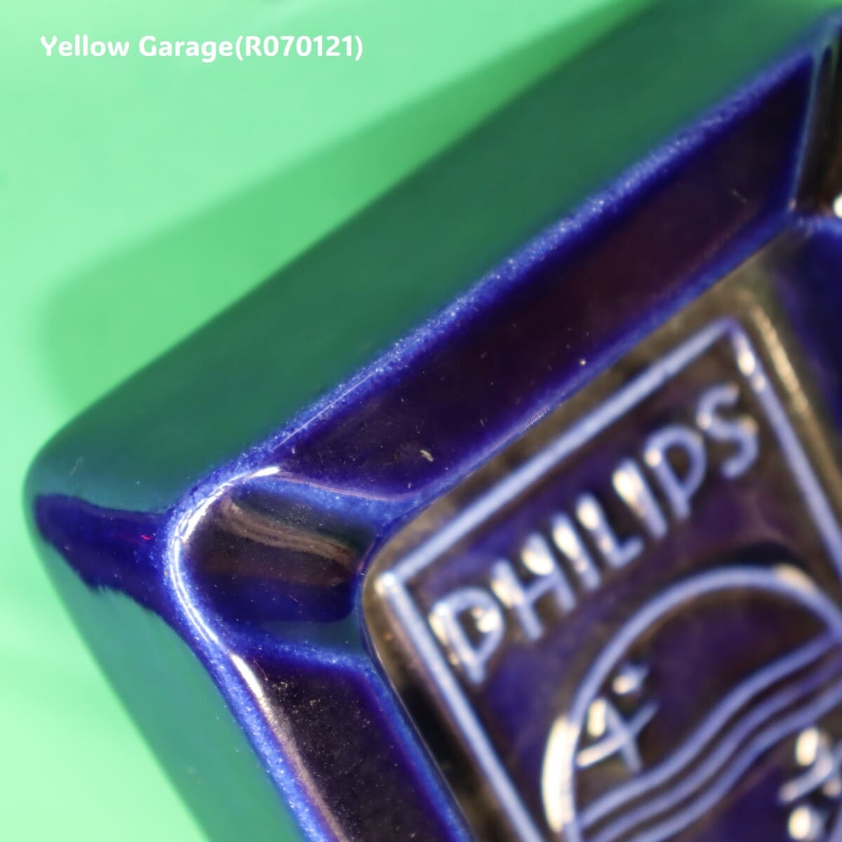 オランダの電機メーカーPHILIPS（フィリップス）のロゴとスローガン「C'EST PLUS SÛR（それはより安全）」が刻まれた深い青の美しい陶器製灰皿＿角アップ