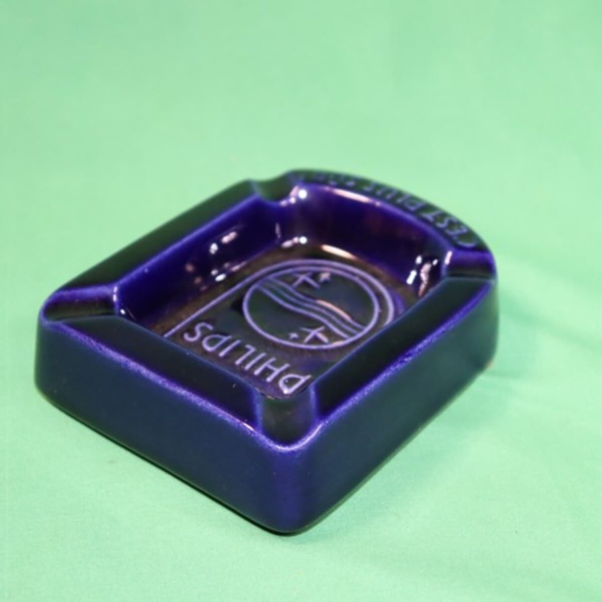 オランダの電機メーカーPHILIPS（フィリップス）のロゴとスローガン「C'EST PLUS SÛR（それはより安全）」が刻まれた深い青の美しい陶器製灰皿＿後ろ反対から斜め