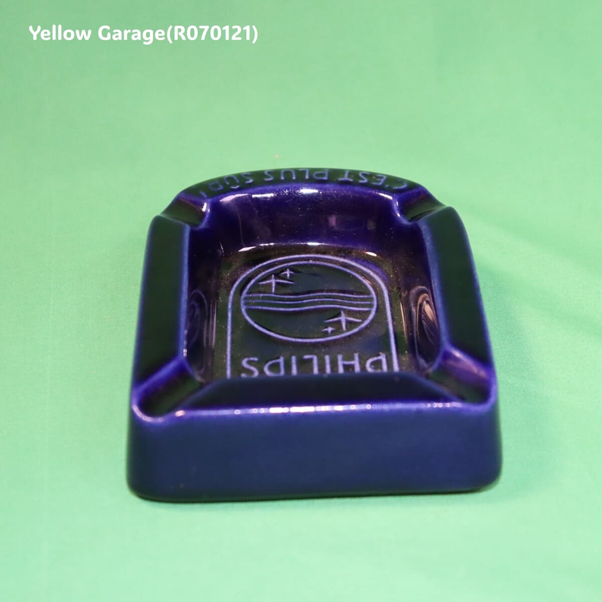 オランダの電機メーカーPHILIPS（フィリップス）のロゴとスローガン「C'EST PLUS SÛR（それはより安全）」が刻まれた深い青の美しい陶器製灰皿＿正面上から