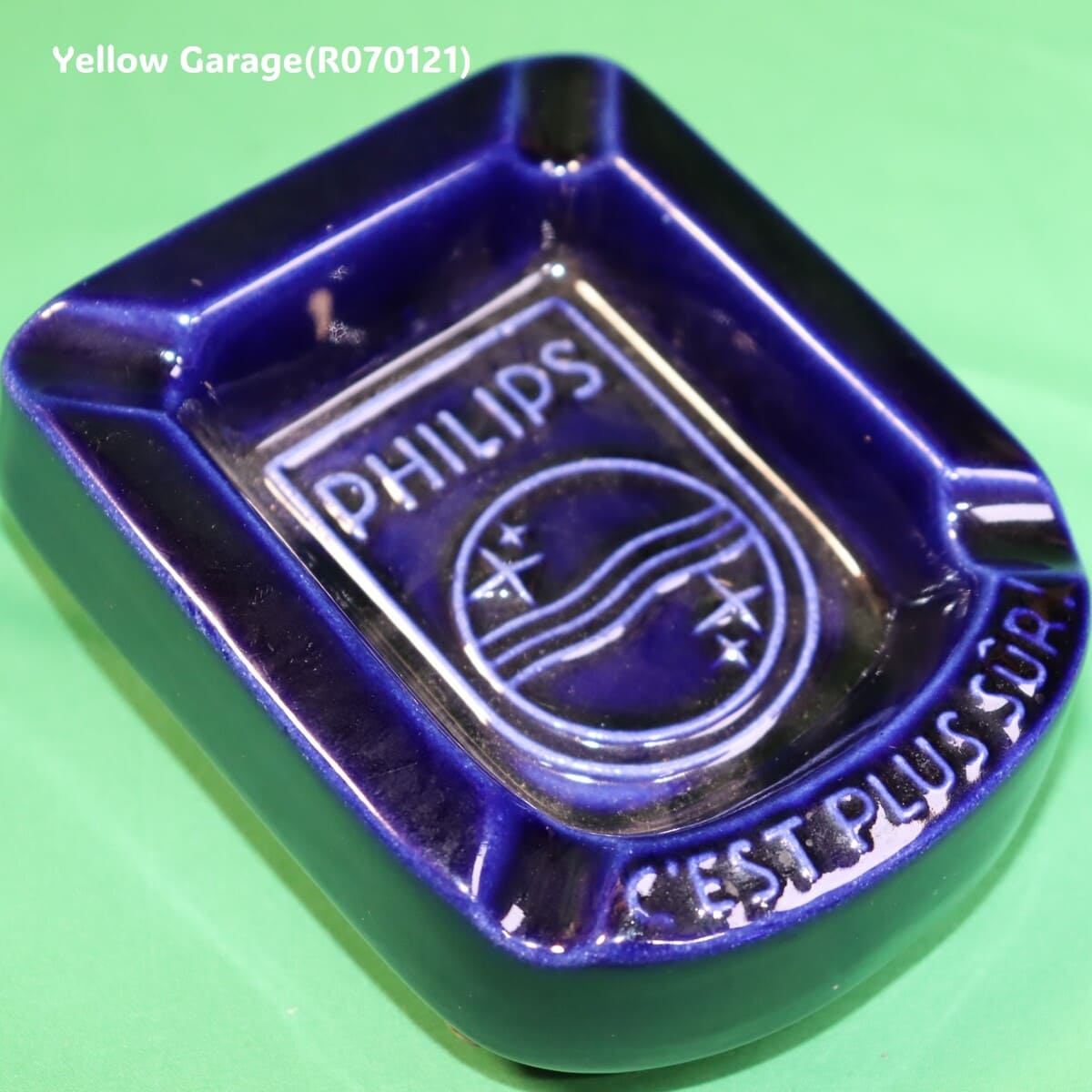 オランダの電機メーカーPHILIPS（フィリップス）のロゴとスローガン「C'EST PLUS SÛR（それはより安全）」が刻まれた深い青の美しい陶器製灰皿＿斜めアップ