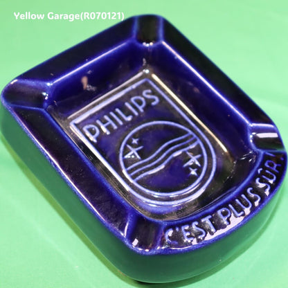オランダの電機メーカーPHILIPS（フィリップス）のロゴとスローガン「C'EST PLUS SÛR（それはより安全）」が刻まれた深い青の美しい陶器製灰皿＿斜めアップ