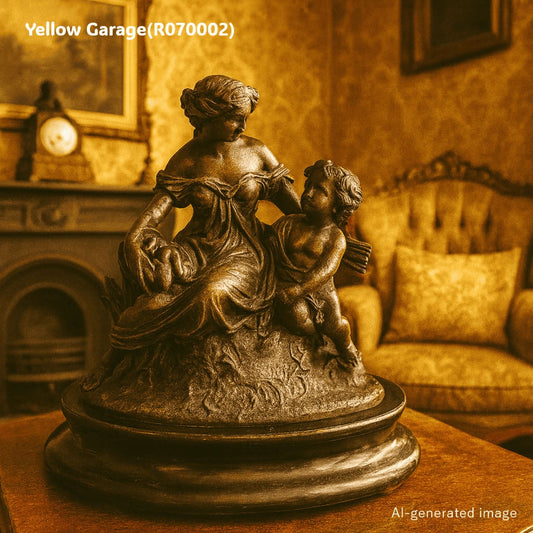 優美な女性像と天使（キューピッド）のような子どもが寄り添うアンチモニー製の置物です。