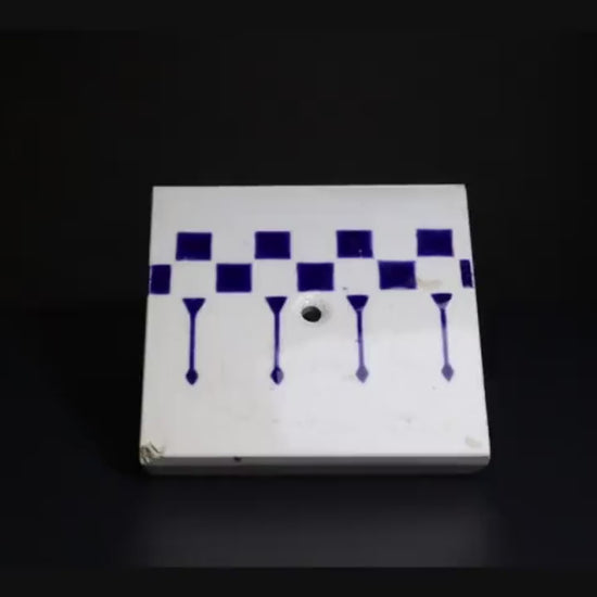 一辺が約85mmの小ぶりなサイズで、白地に深い藍色の幾何学模様（チェッカーボードと縦の矢のようなライン）が描かれています。