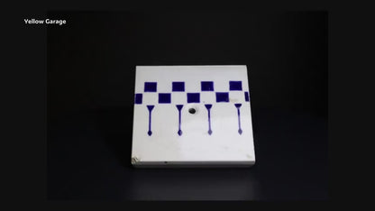 一辺が約85mmの小ぶりなサイズで、白地に深い藍色の幾何学模様（チェッカーボードと縦の矢のようなライン）が描かれています。