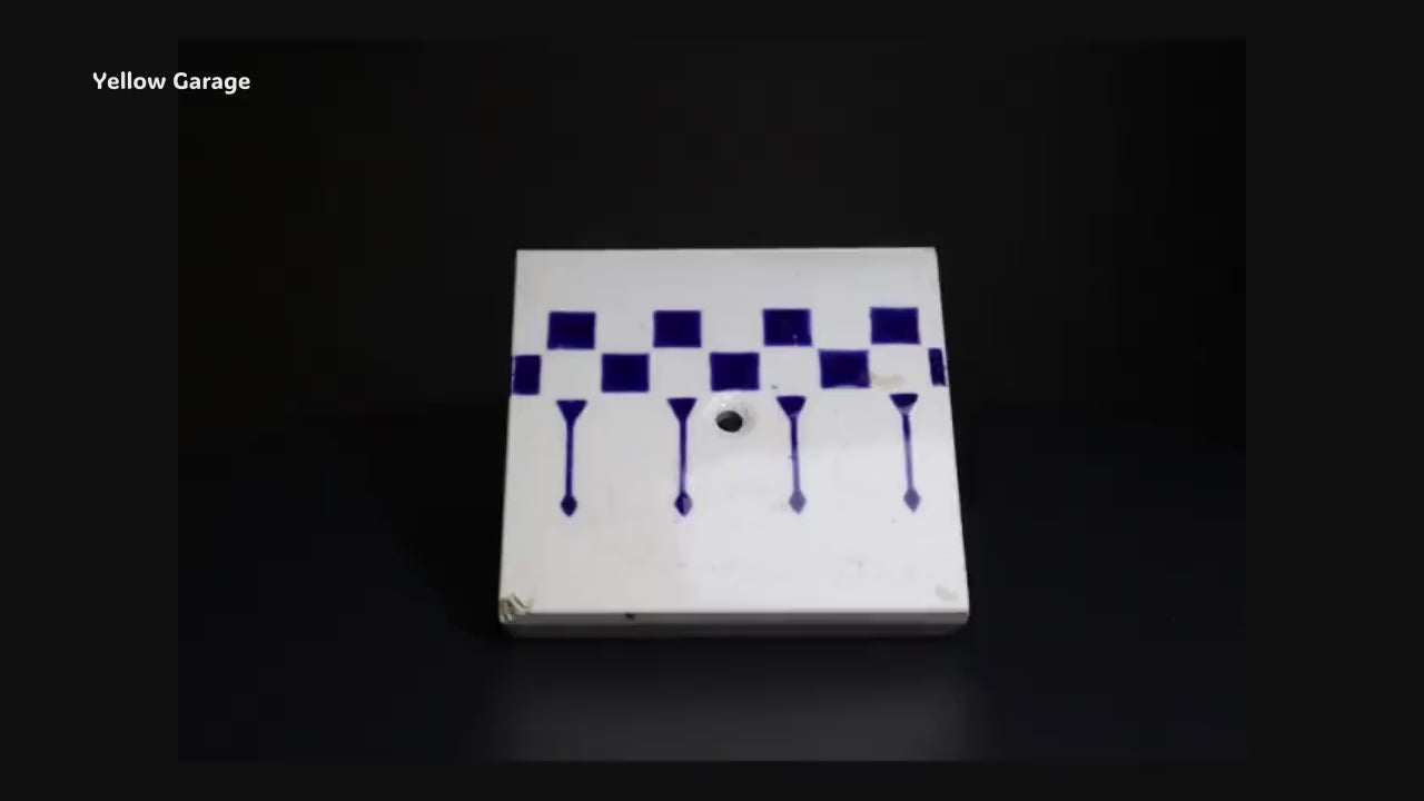 一辺が約85mmの小ぶりなサイズで、白地に深い藍色の幾何学模様（チェッカーボードと縦の矢のようなライン）が描かれています。