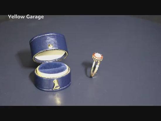 中心には遊色効果が美しいオーストラリア産ホワイトオパール、周囲には天然ルビーと思われる赤い石が繊細に取り巻かれた華やかなアンティークリング